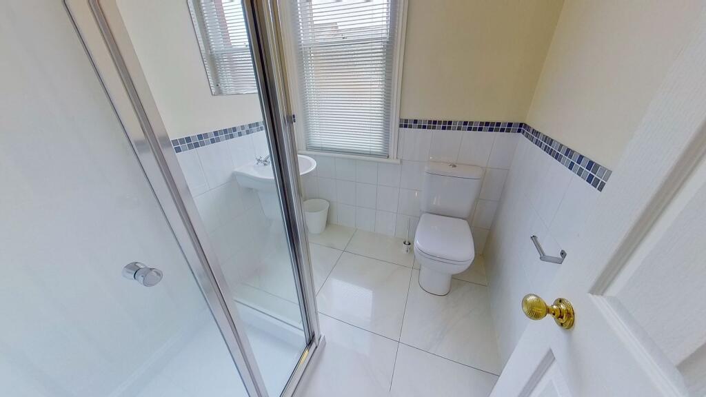 Bright, modern bathroom with a tiled shower enc...