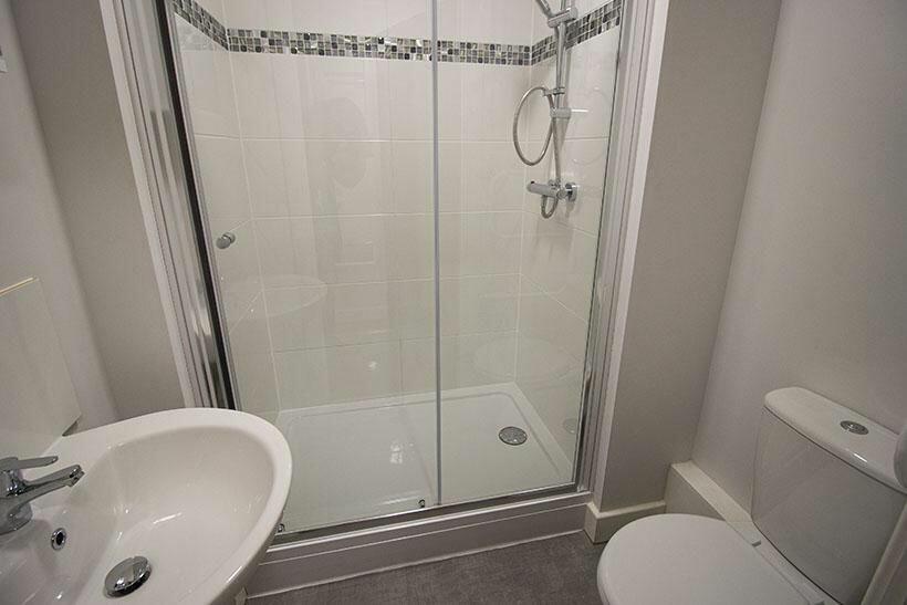 A clean and modern bathroom featuring a glass-e...