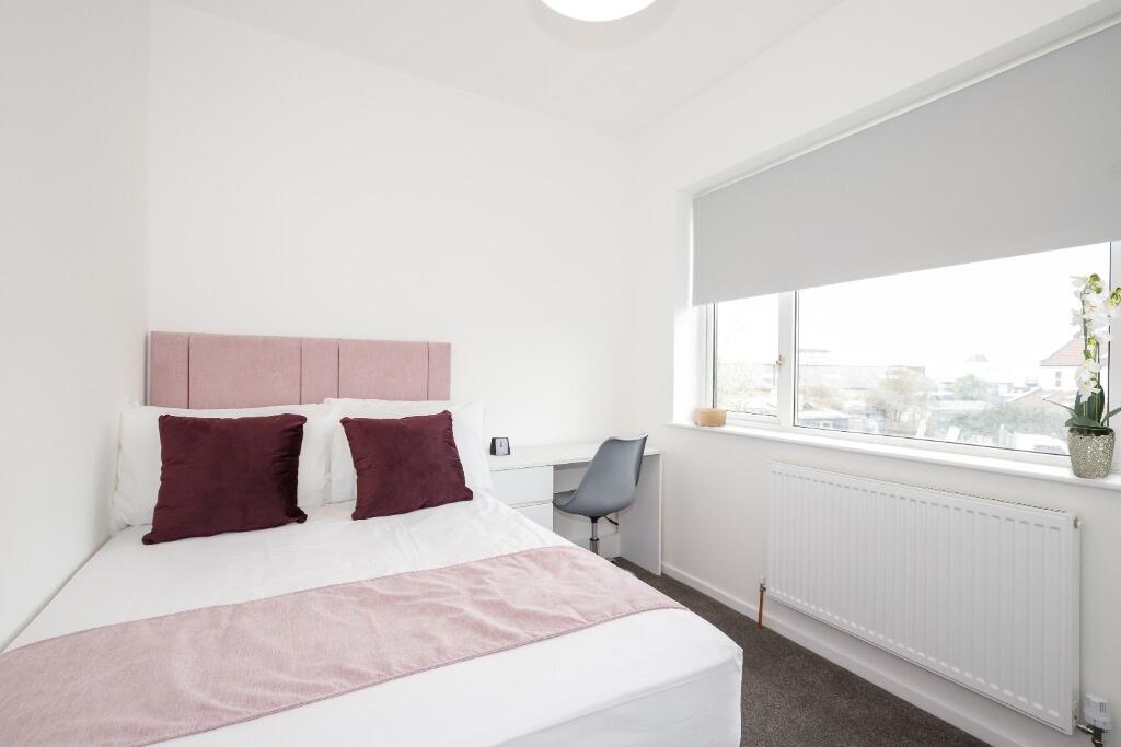 This inviting double bedroom features a comfort...