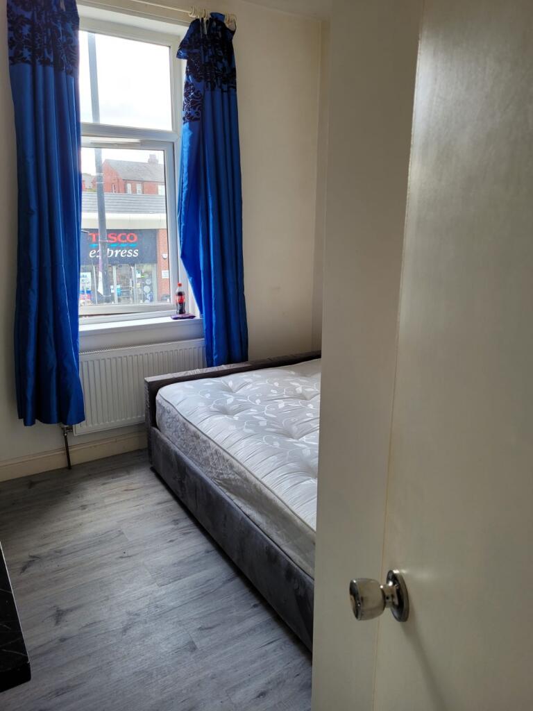 A cozy and clean small bedroom featuring a wind...