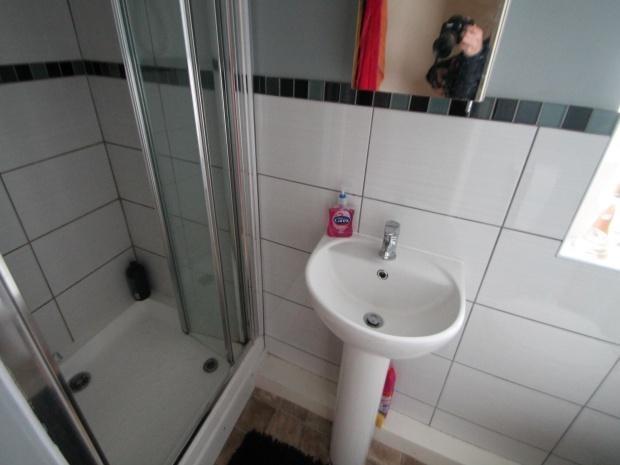 A clean, functional bathroom with a shower and ...
