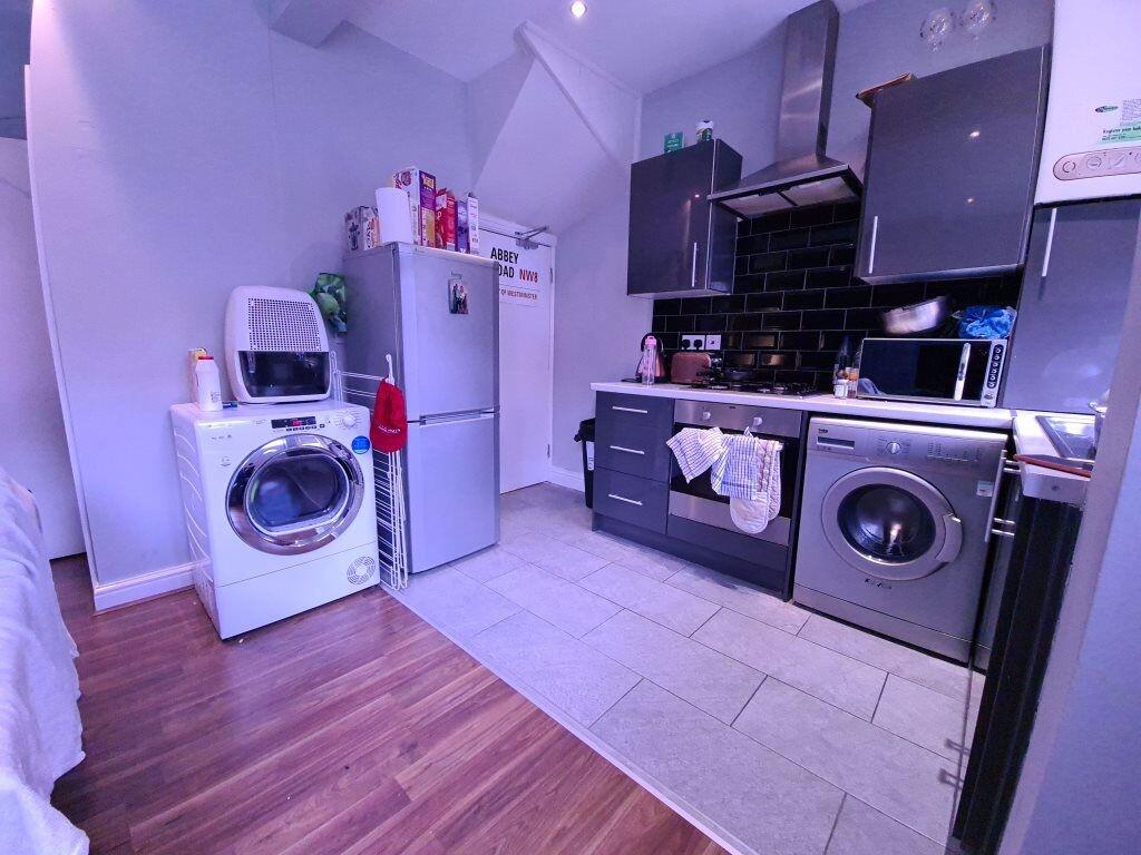A modern kitchen featuring sleek black cabinetr...
