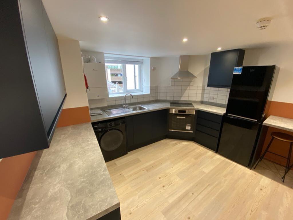 A modern kitchen featuring stylish cabinetry, a...