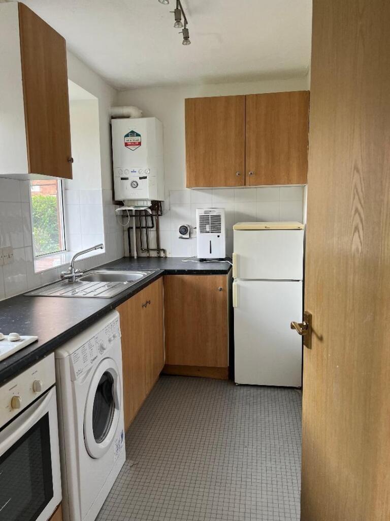 Bright and tidy kitchen with modern wooden cabi...