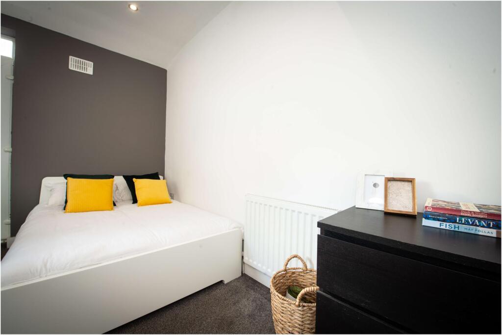 A bright and clean double bedroom featuring a c...