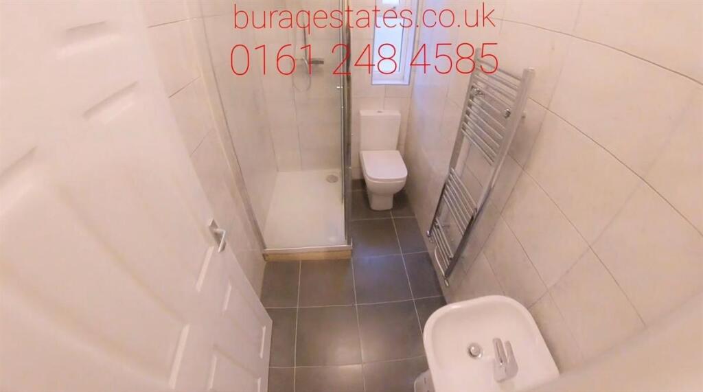 Compact, modern bathroom with tiled walls and f...