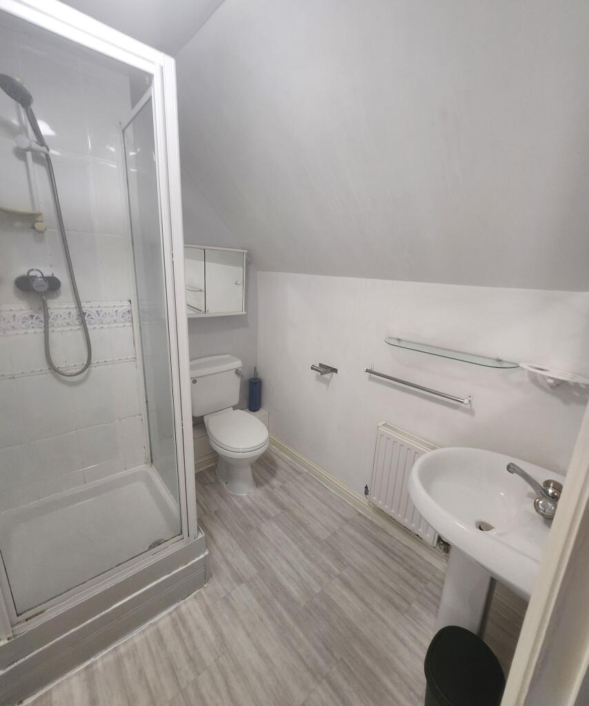 A clean and functional bathroom featuring a sho...