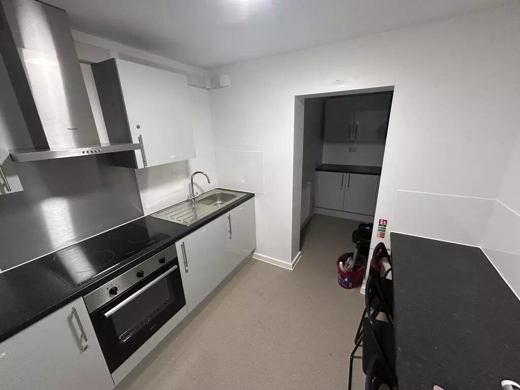 Modern galley kitchen with sleek white cupboard...