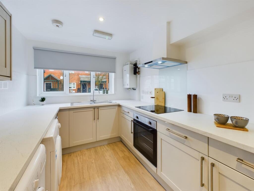 A bright and modern kitchen featuring ample wor...