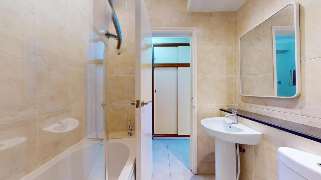 Bright and clean bathroom featuring a shower, s...