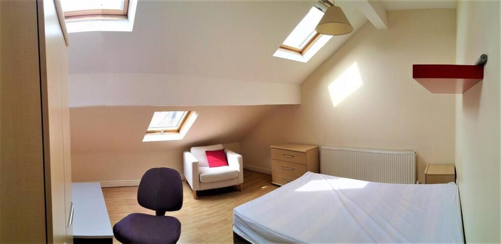 Bright and spacious attic bedroom featuring a c...