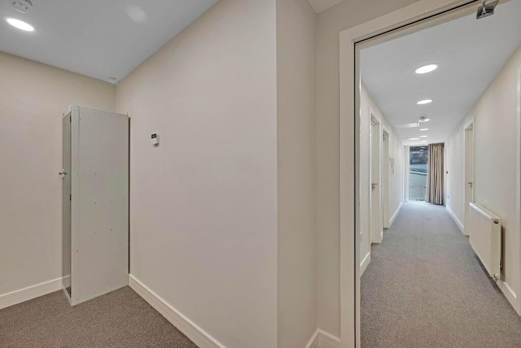 Bright and clean hallway with neutral walls and...