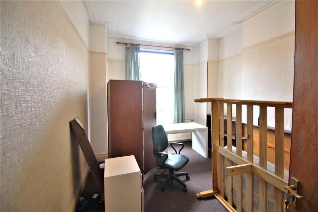 A compact single bedroom featuring a study desk...