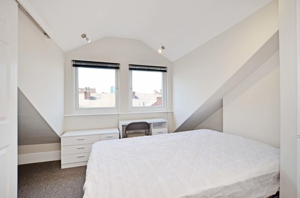 Bright and cozy master bedroom featuring a comf...
