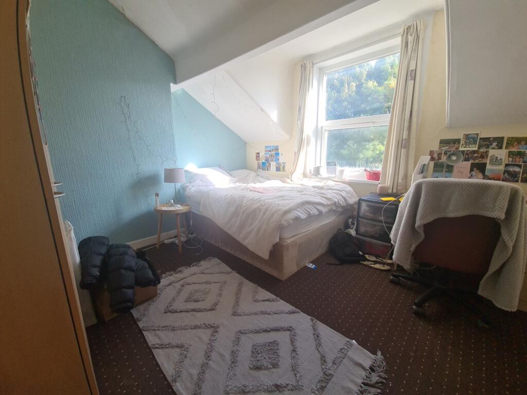 A cozy bedroom featuring a single bed positione...