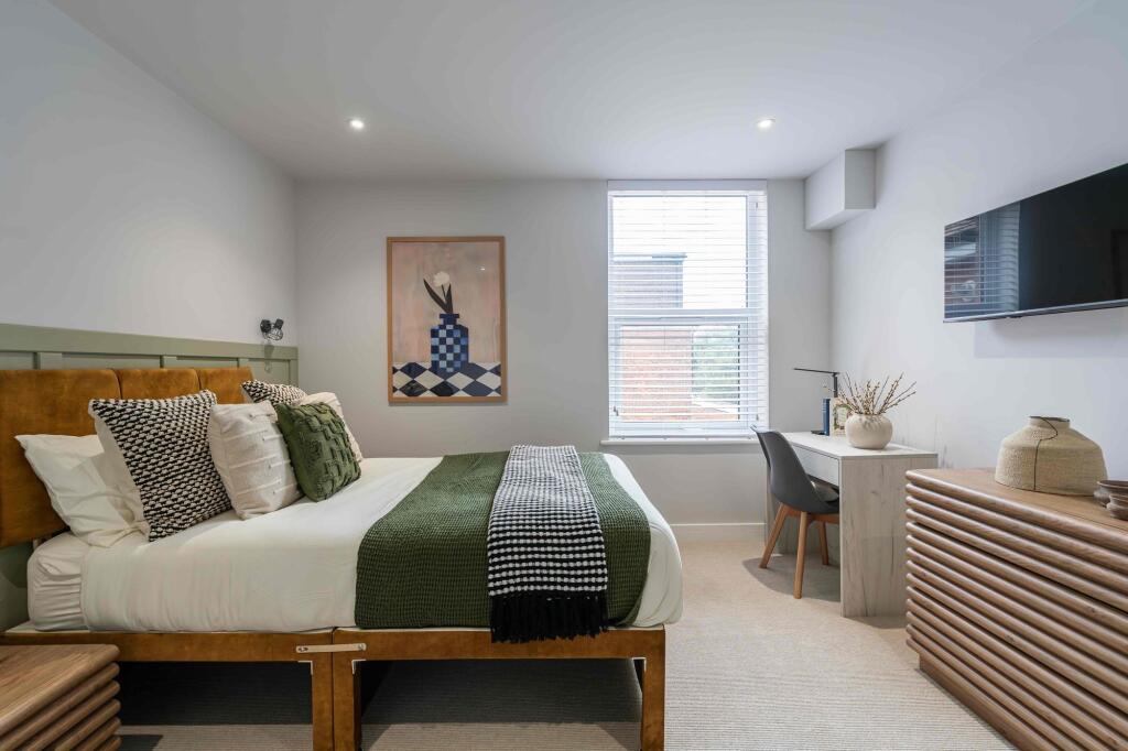 A stylish and spacious master bedroom featuring...