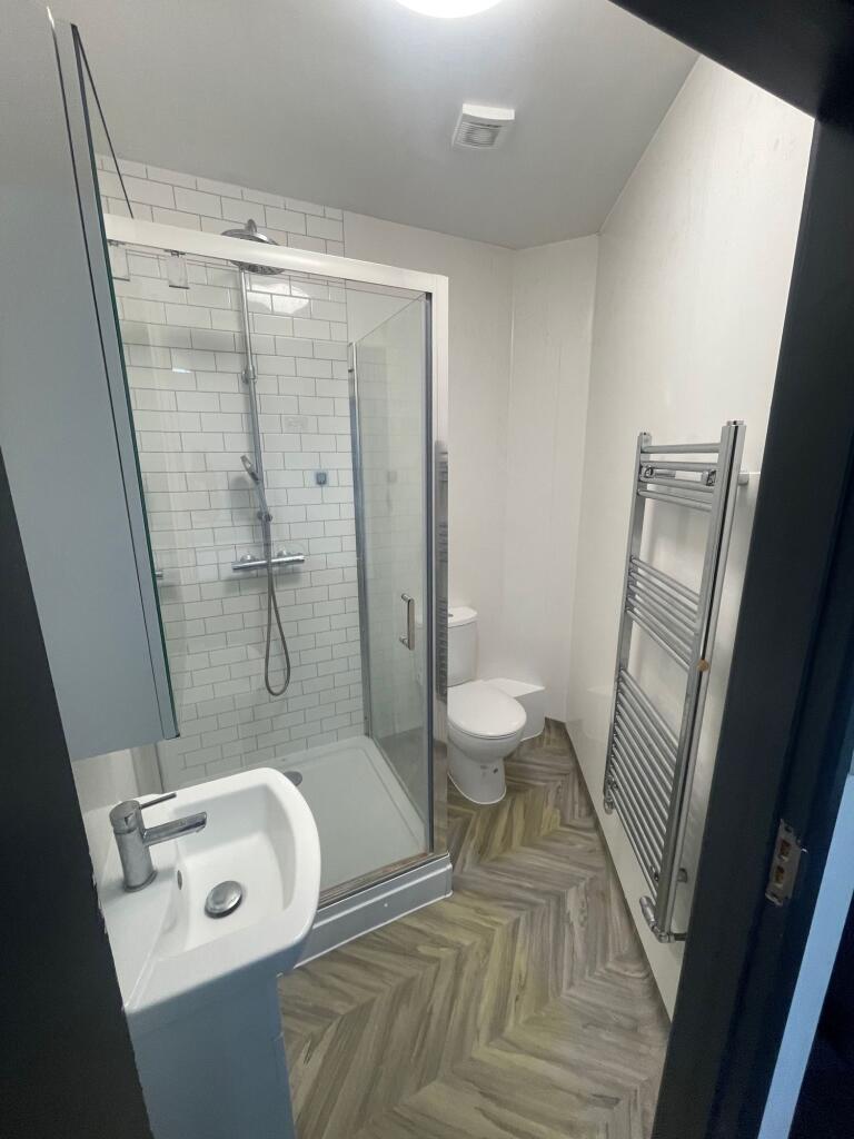 Modern bathroom featuring a glass-enclosed show...