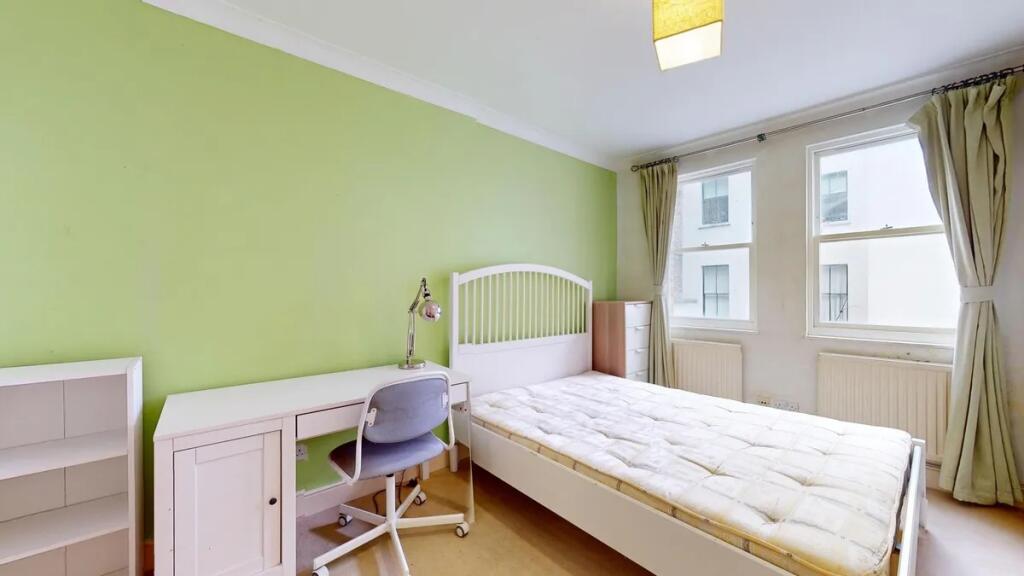 A bright single bedroom featuring a comfortable...