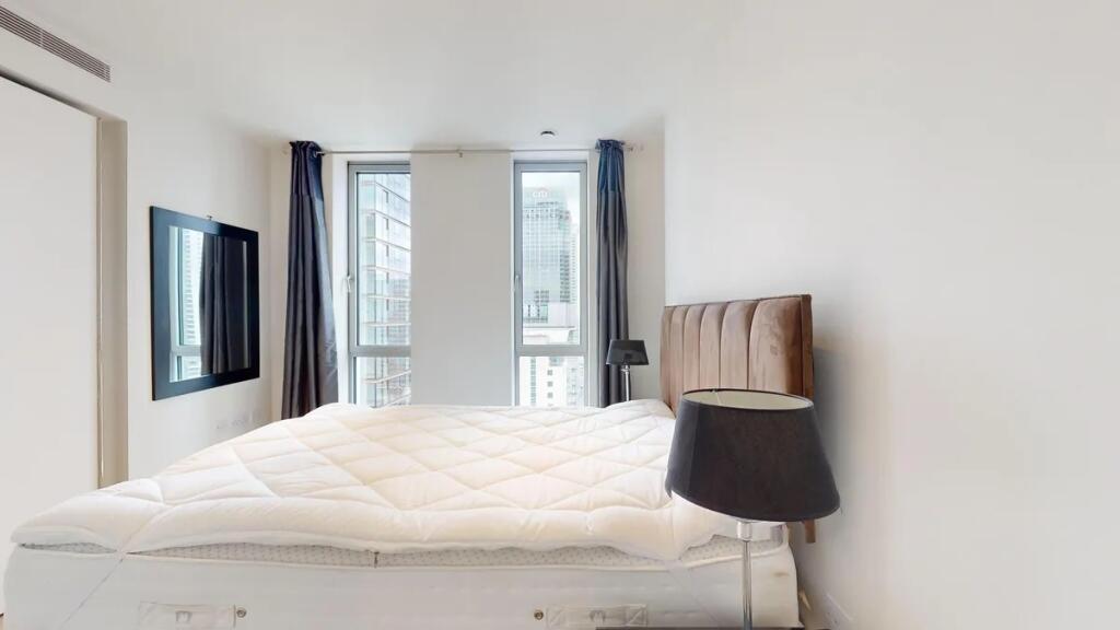 A modern double bedroom featuring a plush uphol...