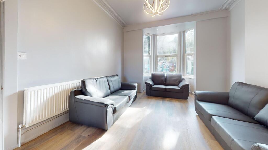 Bright and spacious living room featuring three...