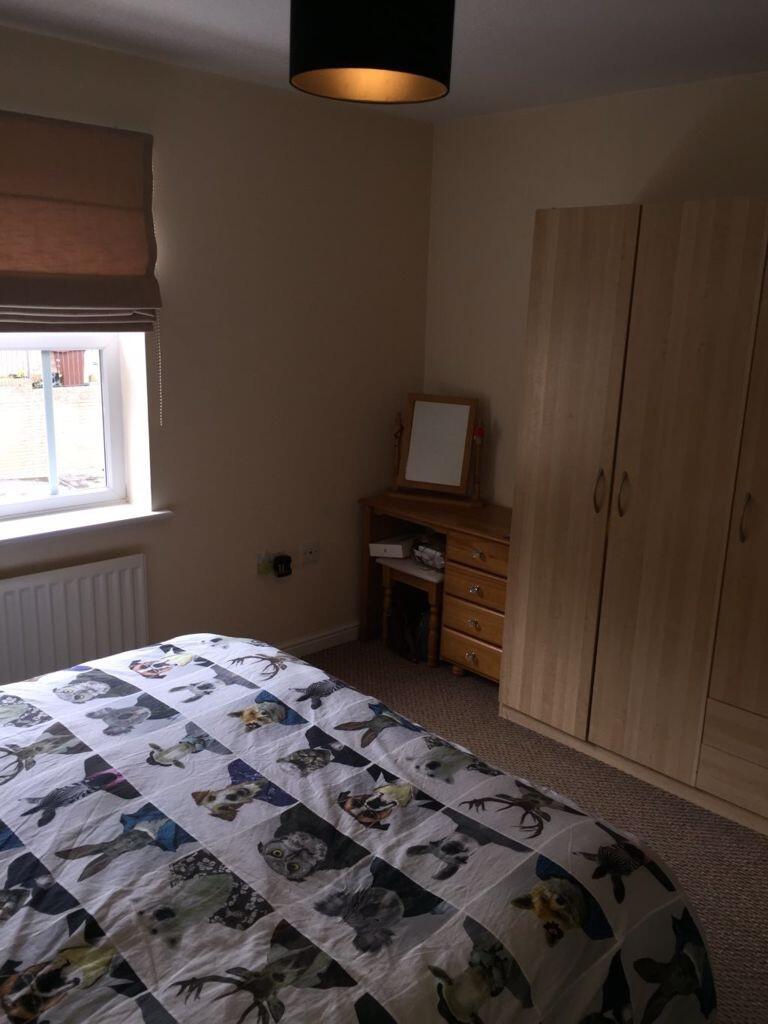 Neat double bedroom with a patterned duvet, fit...