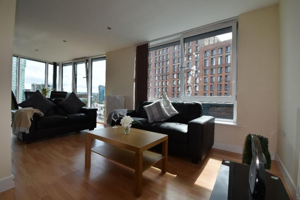 Bright and modern living room featuring large w...