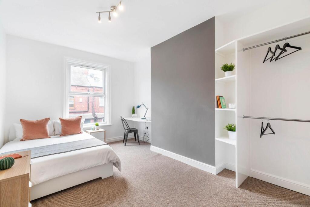 A bright and tidy bedroom featuring a comfortab...