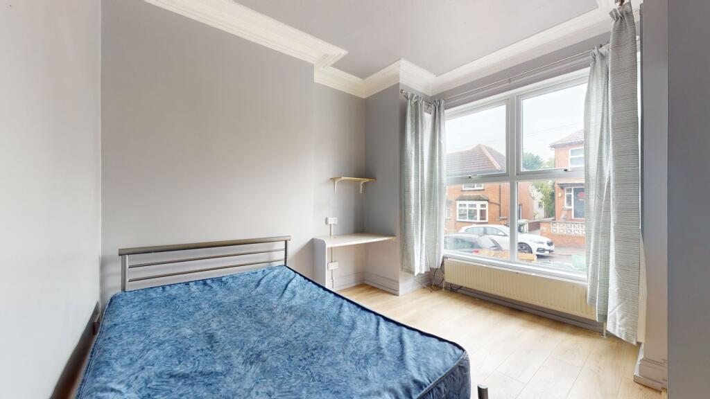 Bright and airy bedroom with a large window off...