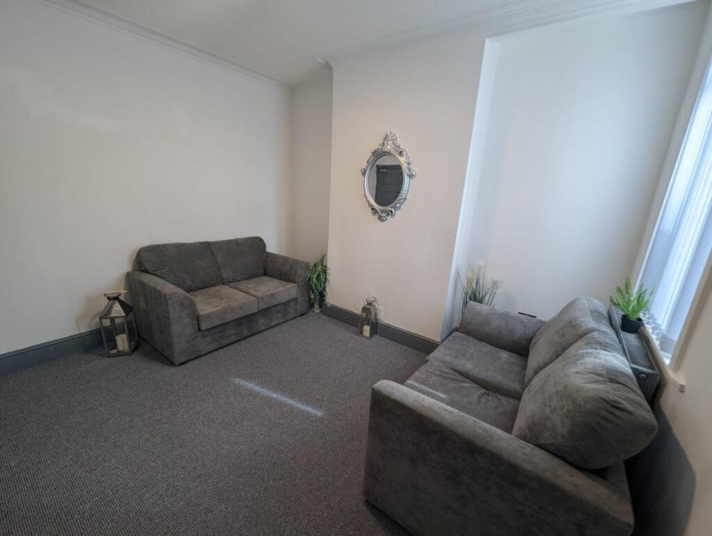A cozy living room featuring two plush grey sof...