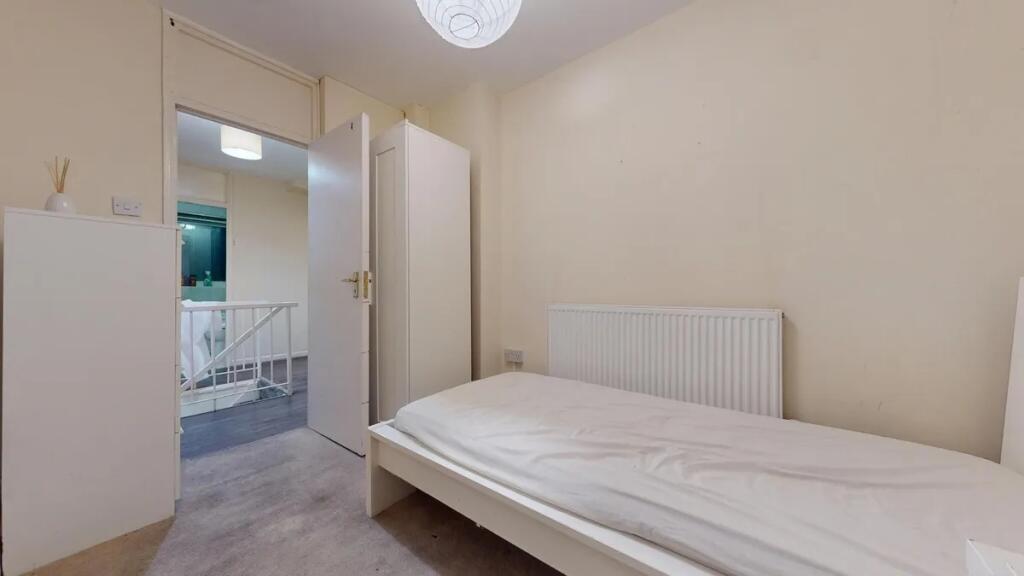 A simple and functional single bedroom with a w...