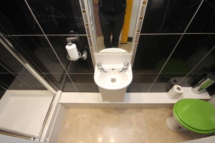 Modern bathroom with sleek black tiled walls, a...