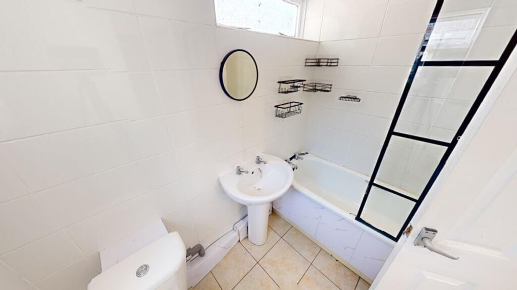 A bright and tidy bathroom featuring a bath and...