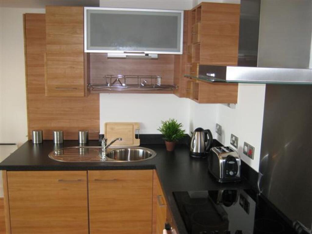A modern kitchen featuring sleek wooden cabinet...