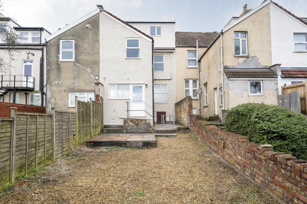 The back view of a house with a spacious garden...
