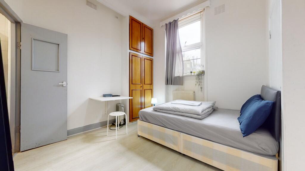 A bright and tidy single bedroom with a comfort...