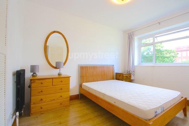 A bright and tidy bedroom featuring a wooden do...