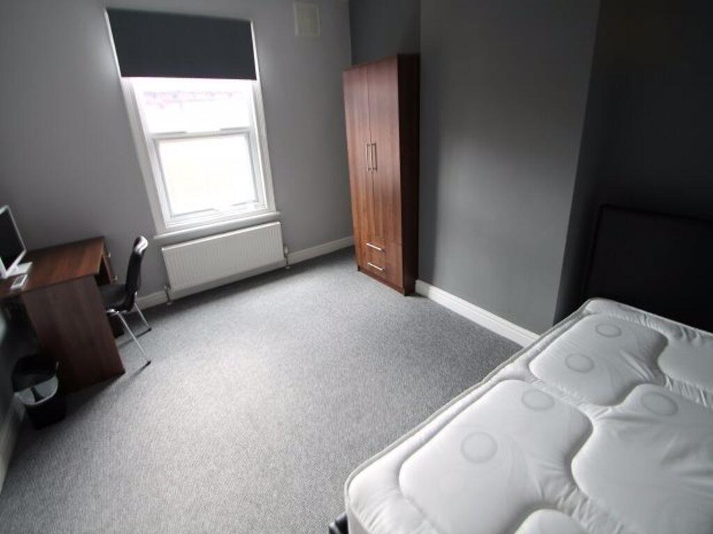 A neat and tidy single bedroom featuring a larg...