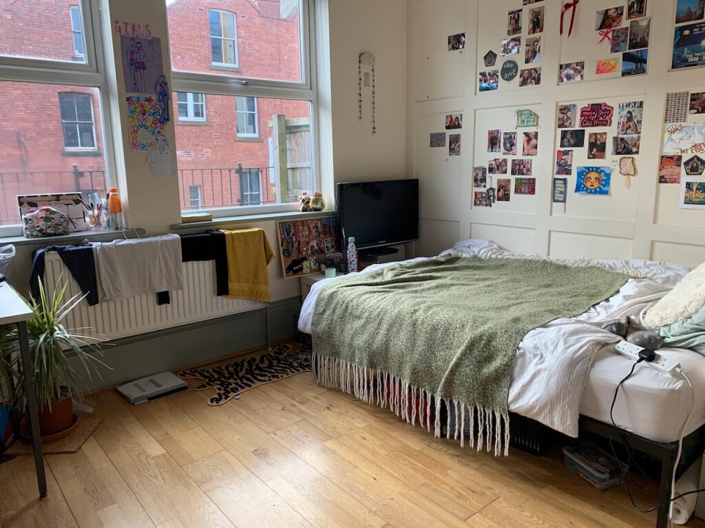 A cozy and well-lit single bedroom featuring a ...