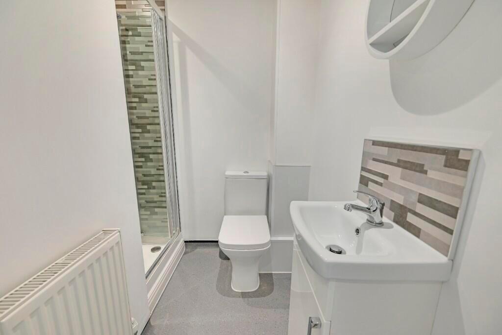Bright and clean bathroom suite featuring a mod...