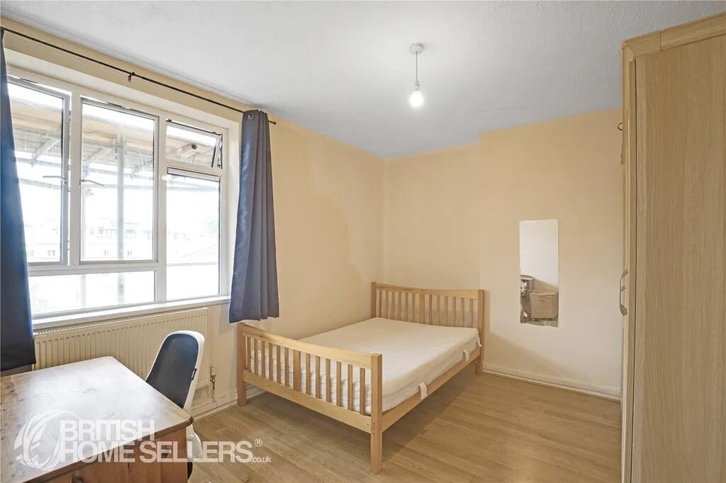 A cozy student bedroom featuring a wooden bed f...