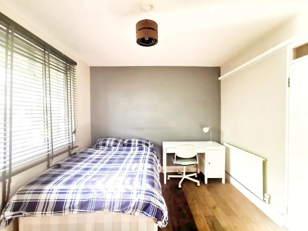 Bright and tidy double bedroom featuring a comf...