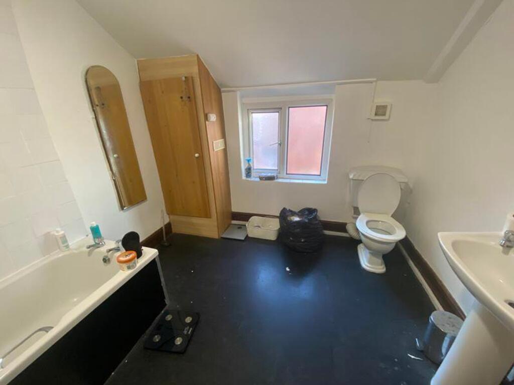 A spacious bathroom featuring a bath and modern...
