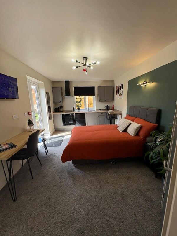 A stylish and spacious master bedroom featuring...