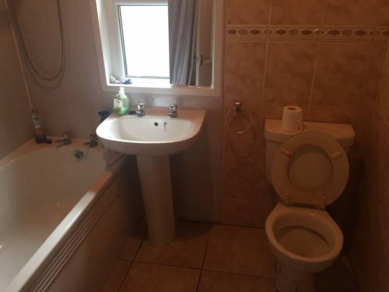 A functional bathroom suite featuring a bathtub...