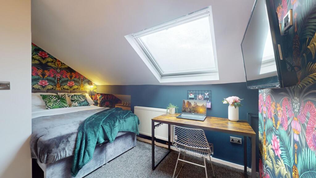 This inviting double bedroom features a cozy be...