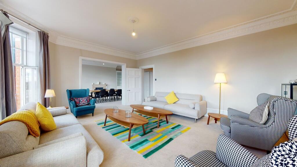A spacious and stylish living room featuring tw...