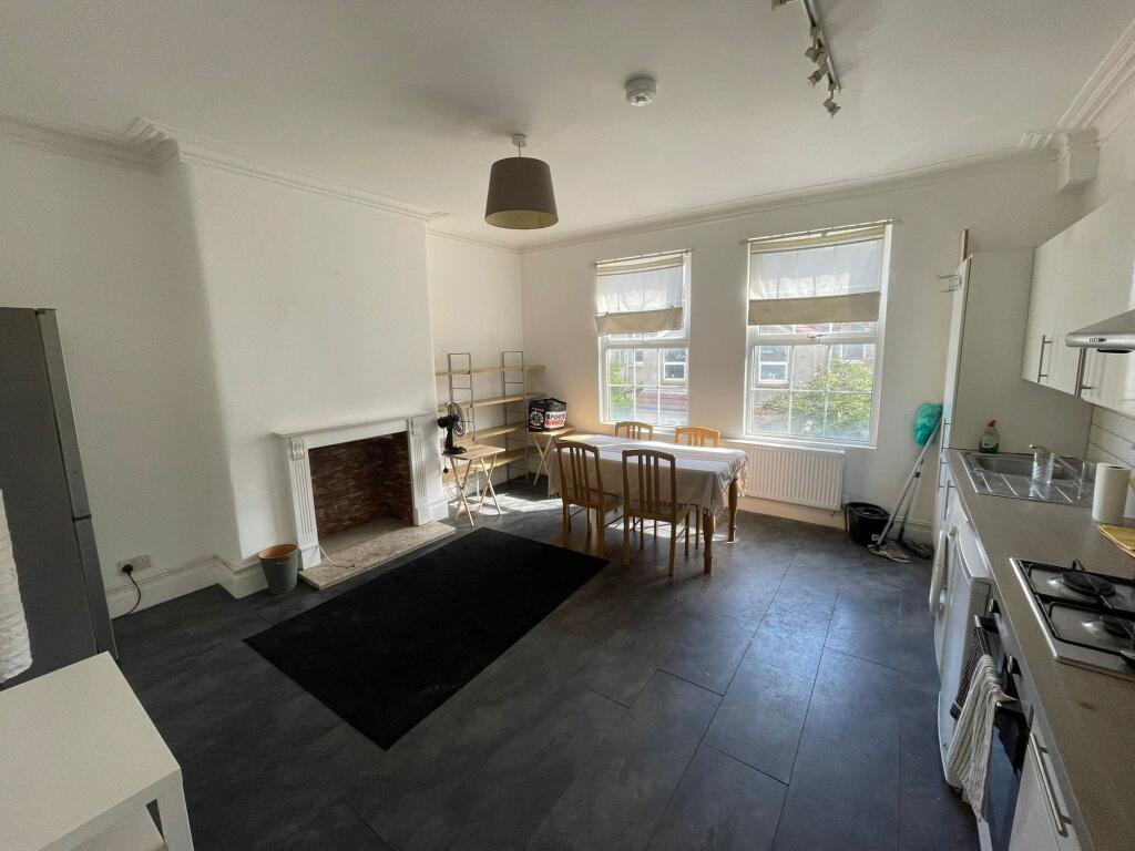 Bright and spacious living area with large wind...
