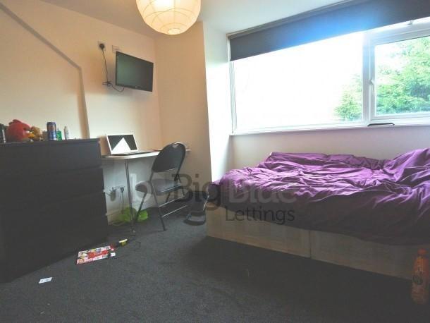 A cozy single bedroom featuring a large window ...