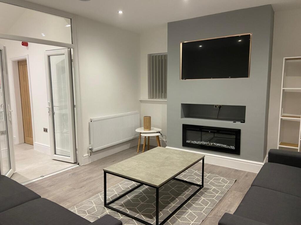 Contemporary living room with a wall-mounted TV...