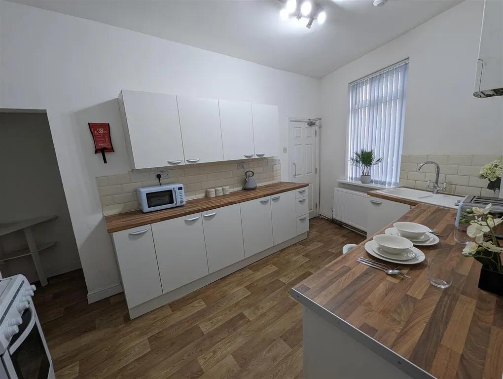 Bright and modern kitchen featuring white cabin...